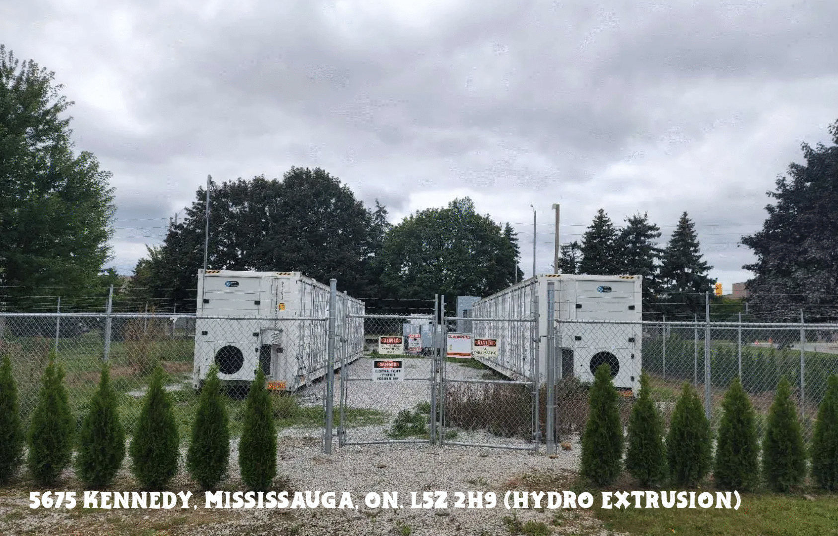 Construction site with concrete walls and machinery under cloudy skies.