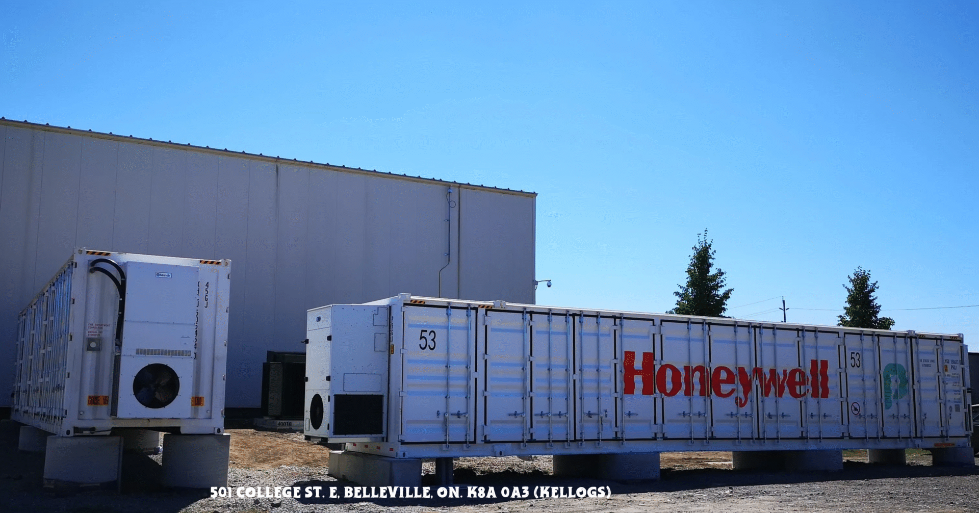 A Honeywell shipping container outside a warehouse under a clear blue sky.