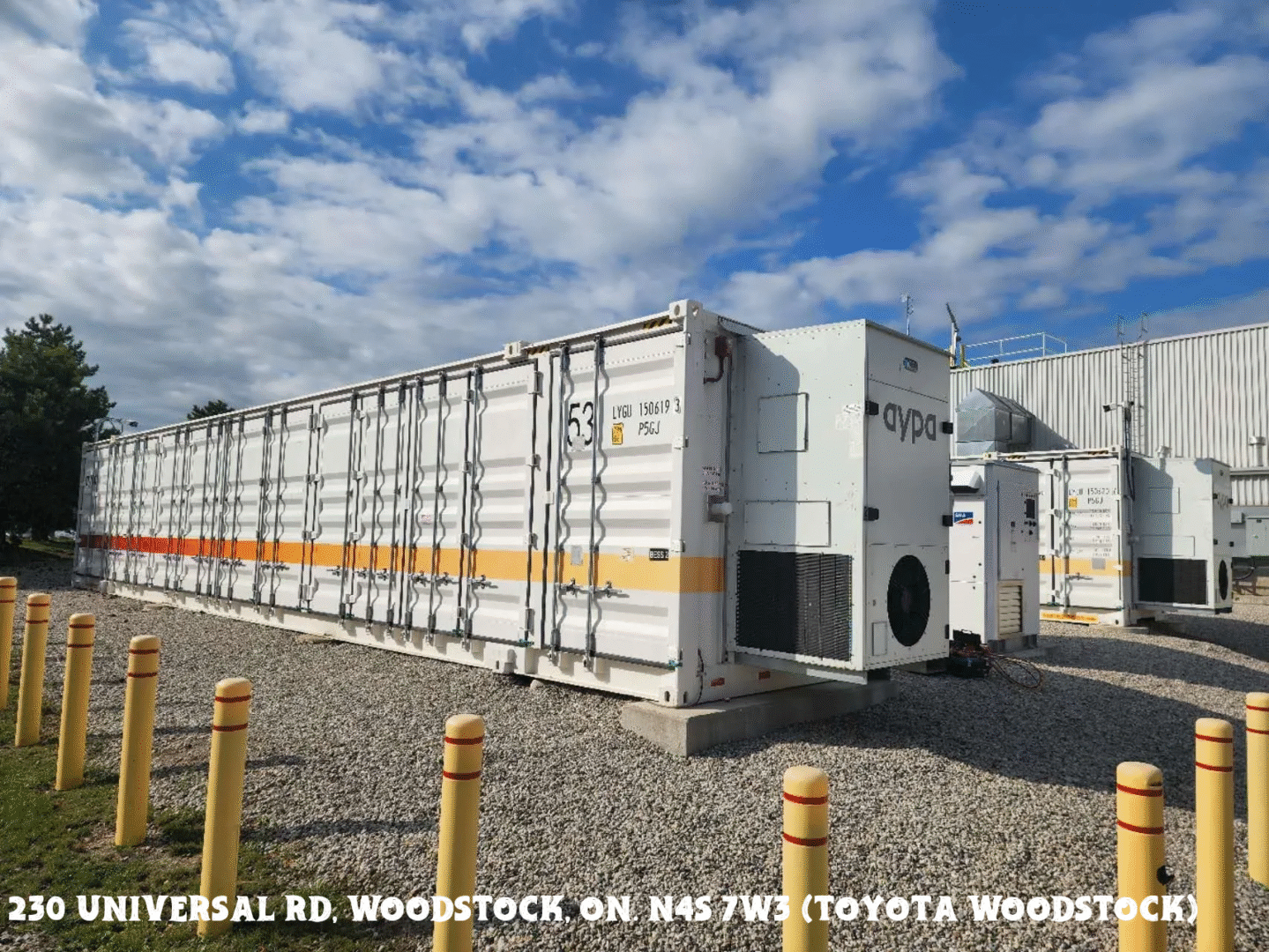 Rows of large white industrial containers under a partly cloudy sky.